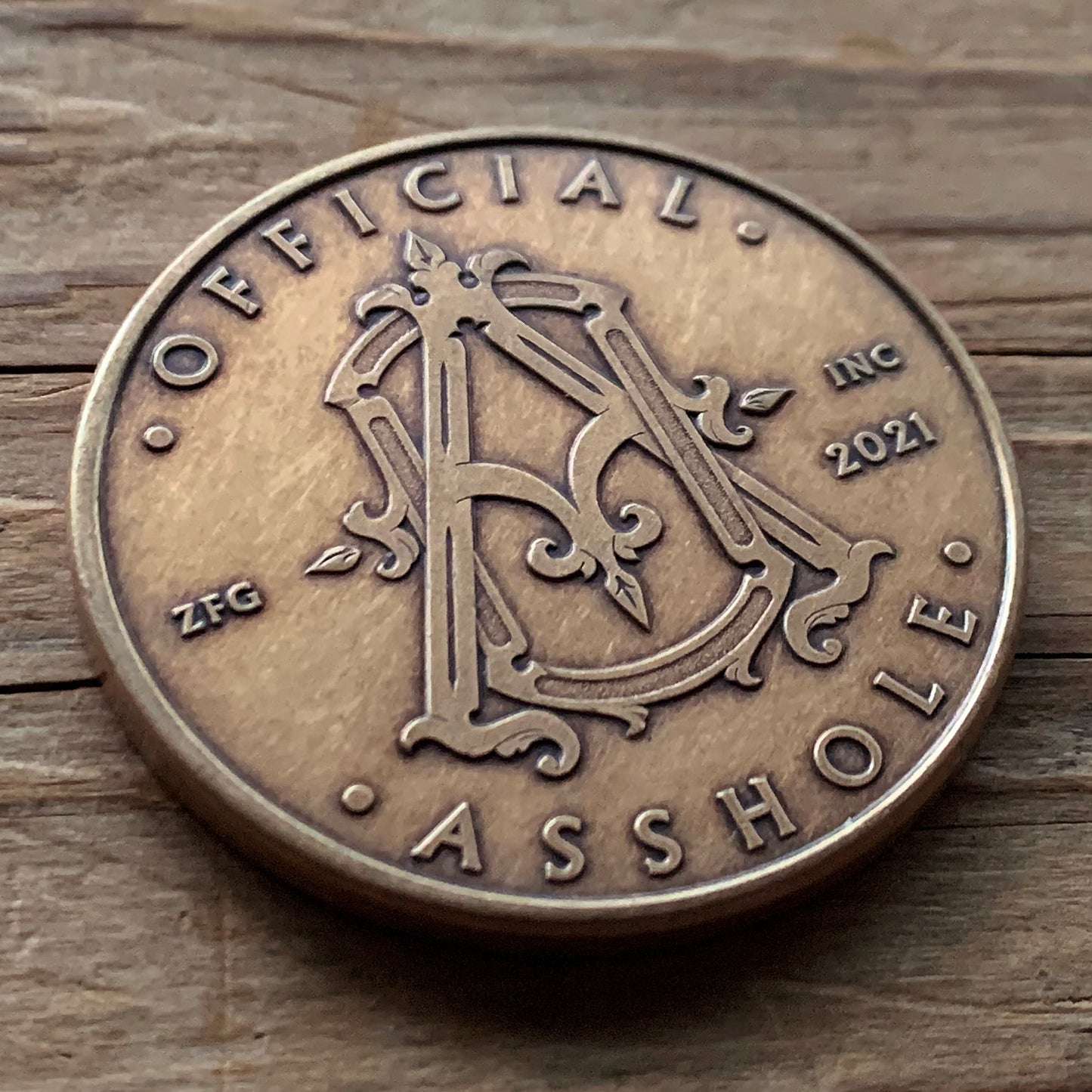 Official Asshole Coin Front on Wood
